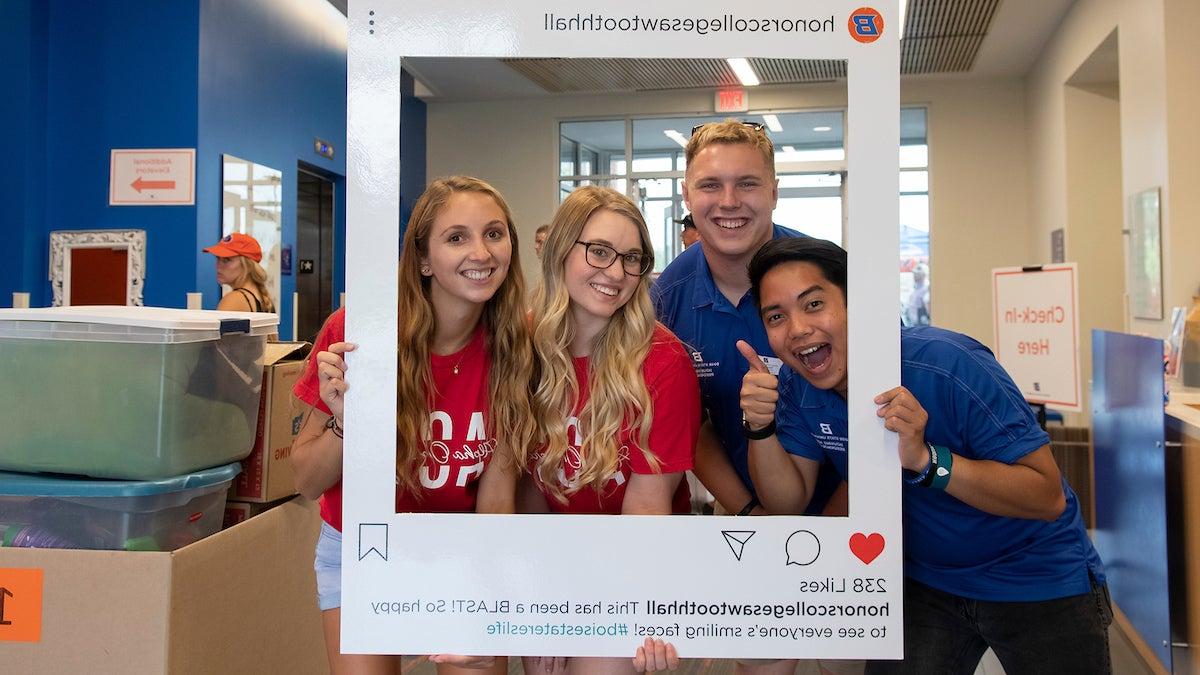 Students hold oversize Instagram frame for Honors College Sawtooth Hall. 